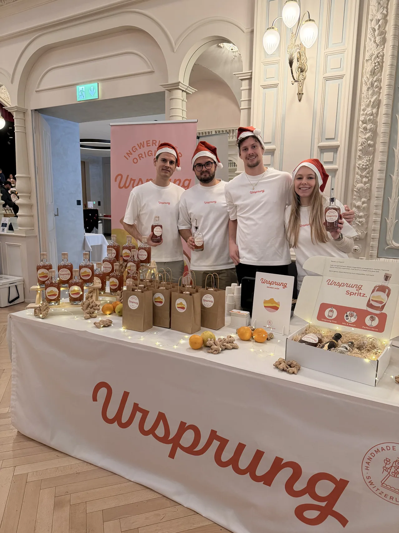 Das Ursprung-Team mit Weihnachtsmützen am Verkaufsstand